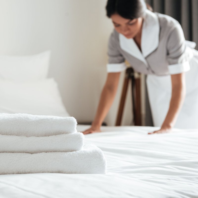 a hotel worker makes the bed