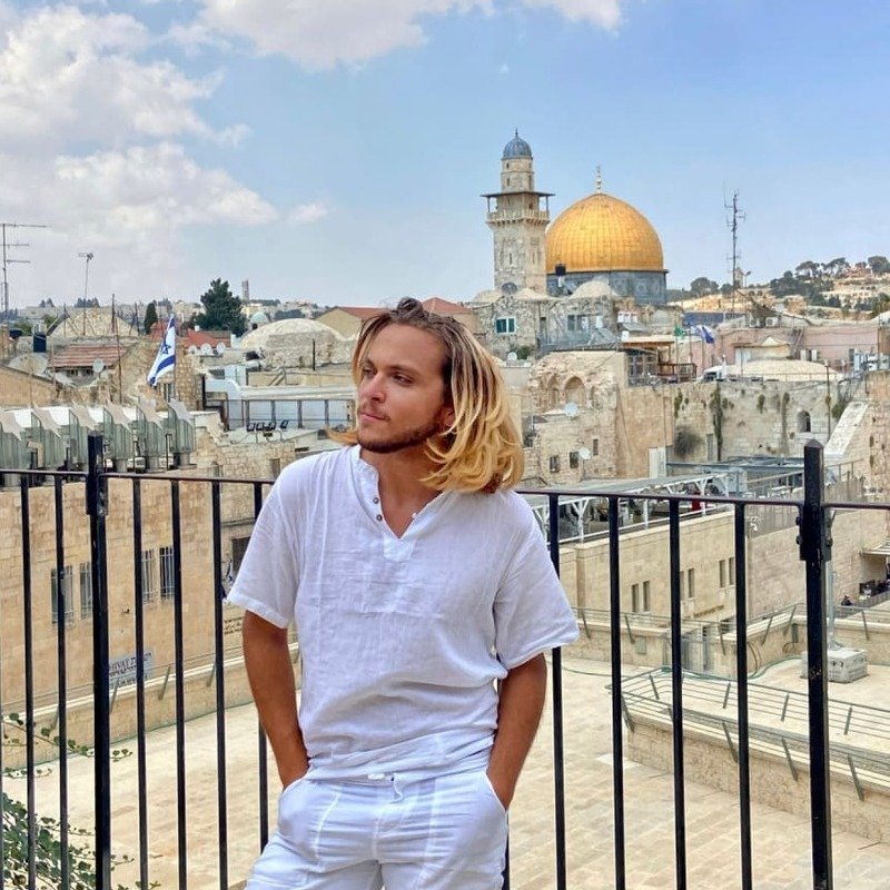 Young Male Tourist Posing For A Picture In A Lookout Point Overlooking The Western Wall And Temple Mount In Jerusalem, IsraelYoung Male Tourist Posing For A Picture In A Lookout Point Overlooking The Western Wall And Temple Mount In Jerusalem, Israel