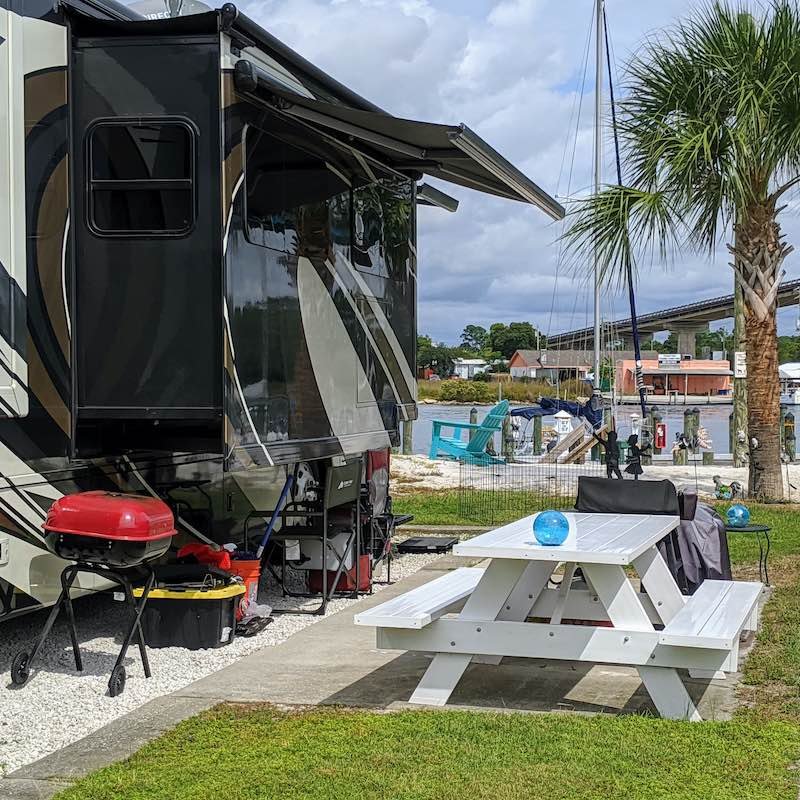 Camping site next to river with RV and picnic table