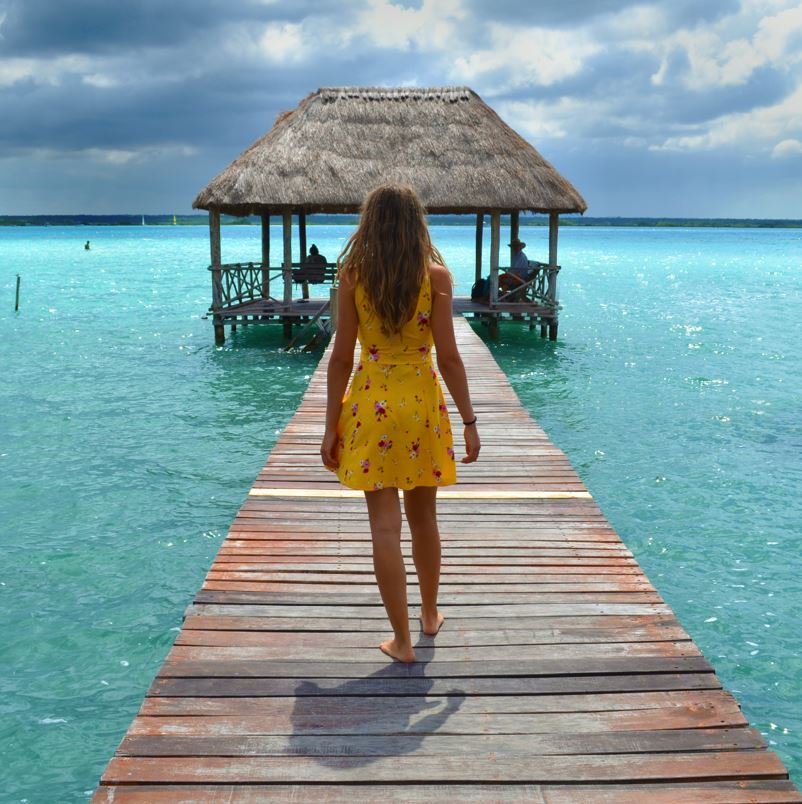 Lake Bacalar with woman walking along dock, destinations