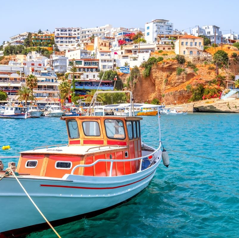 Crete, Greece with boat in the foreground and village in the background