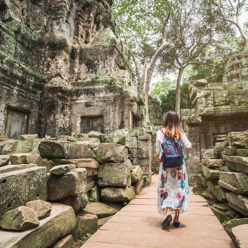 Young Female Tourist Visiting The Ta Prohm Temple In Cambodia, Southeast Asia