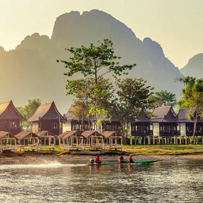 Traditional Bungalows Along Nam Song River In Laos During Sunset, Southeast Asia