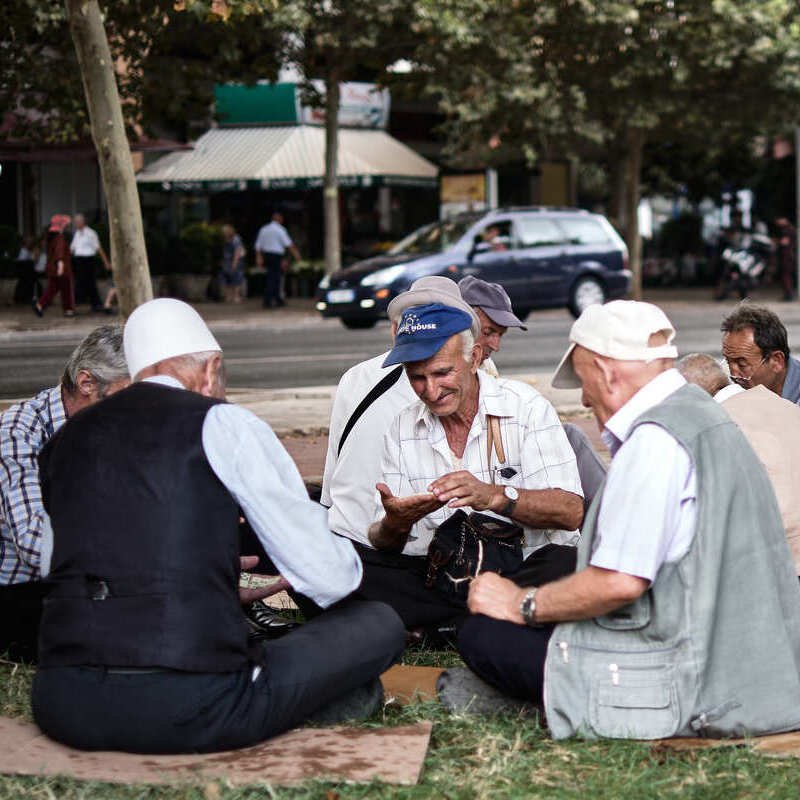 Friendly Looking Old Albanian Gentlemen Playing A Card Game On The Street, Unspecified Location In Albania, Eastern Europe