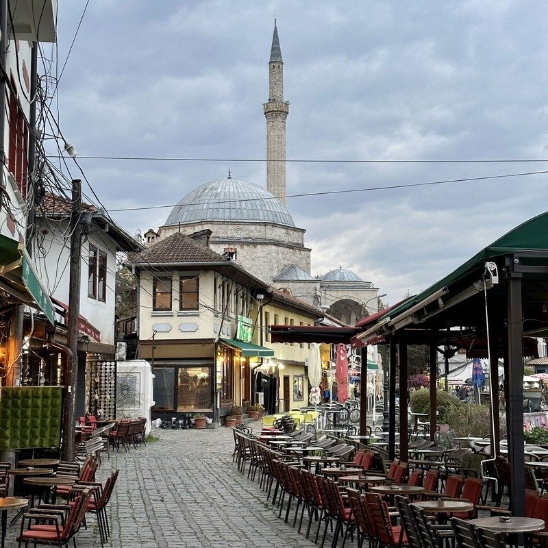 Cobblestone Street In The Old Town Of Prizren Lined With Restaurants And Cafes, Leading To An Ottoman Mosque, Prizren, Kosovo, Eastern Europe