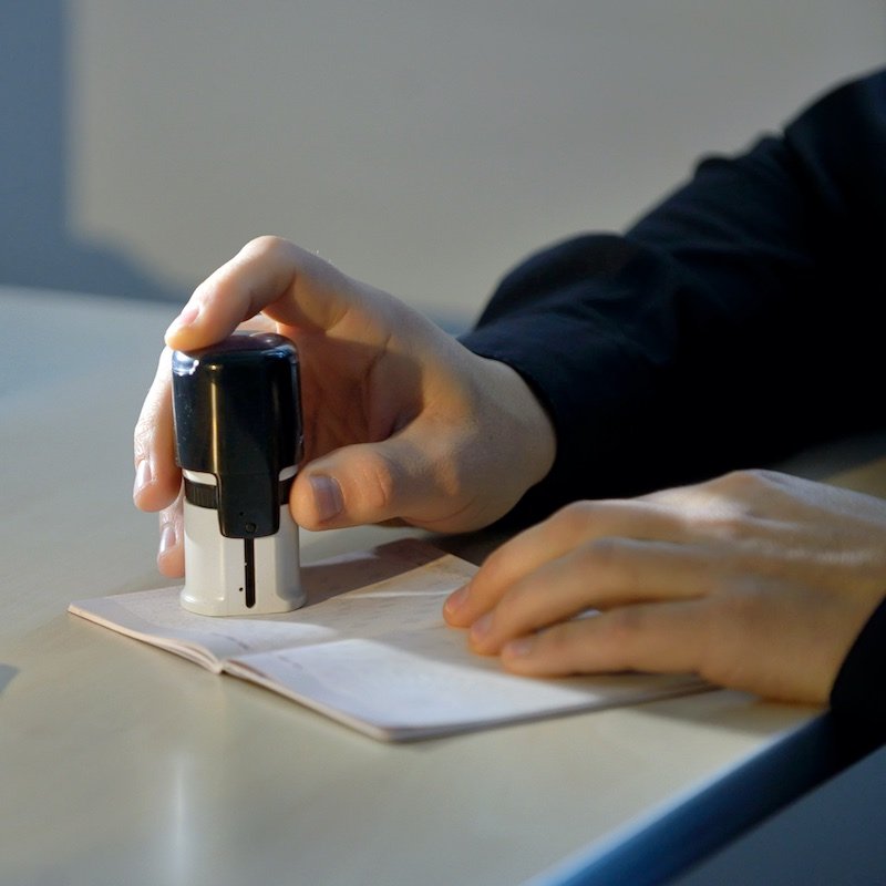 Custom Officer Stamping A Passport During International Border Crossing, International Travel Concept