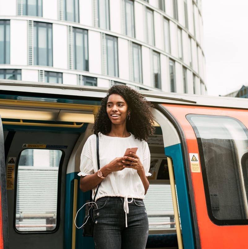 Confident young woman getting off of the tube train in london