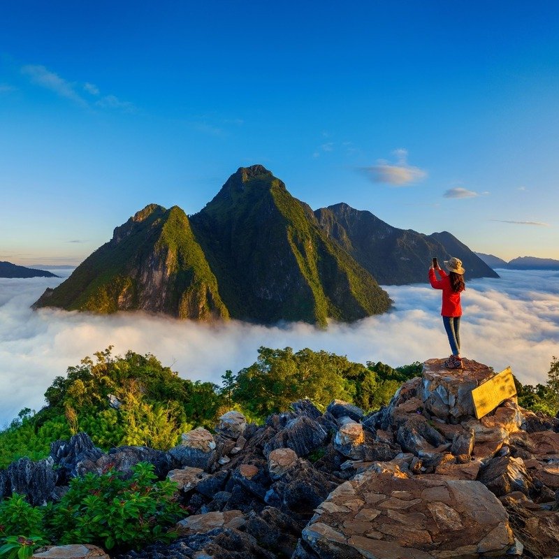 Panorama Of Tourist Wearing A Red Jacket Taking A Picture Of A Mountain Scenery In Laos, Southeast Asia