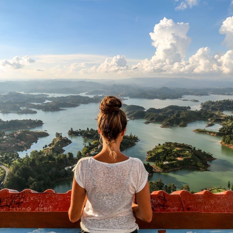 Female Tourist Admiring The Landscape From Atop Penol De Guatape, The Landmark Rock In Guatape, Antioquia Region Of Colombia