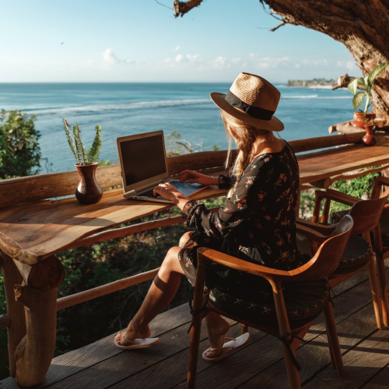 woman outside on laptop  at beach 
