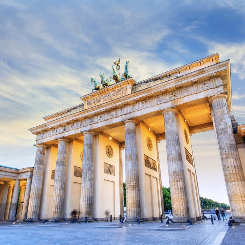 The Brandenburg Gate, Berlin, Germany. Long stems on the bridge showcase a statue of four horses. 
