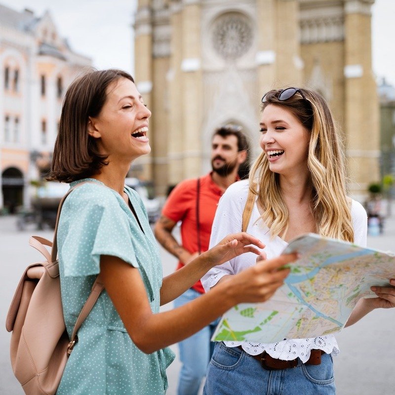 Female Friends Checking A Map In The City Of Novi Sad, Serbia, In Eastern Europe, Balkan Peninsula