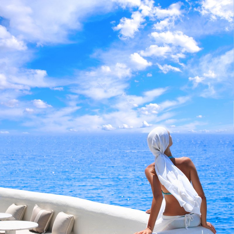 woman relaxing in the afternoon by the sea in Santorini Greece.