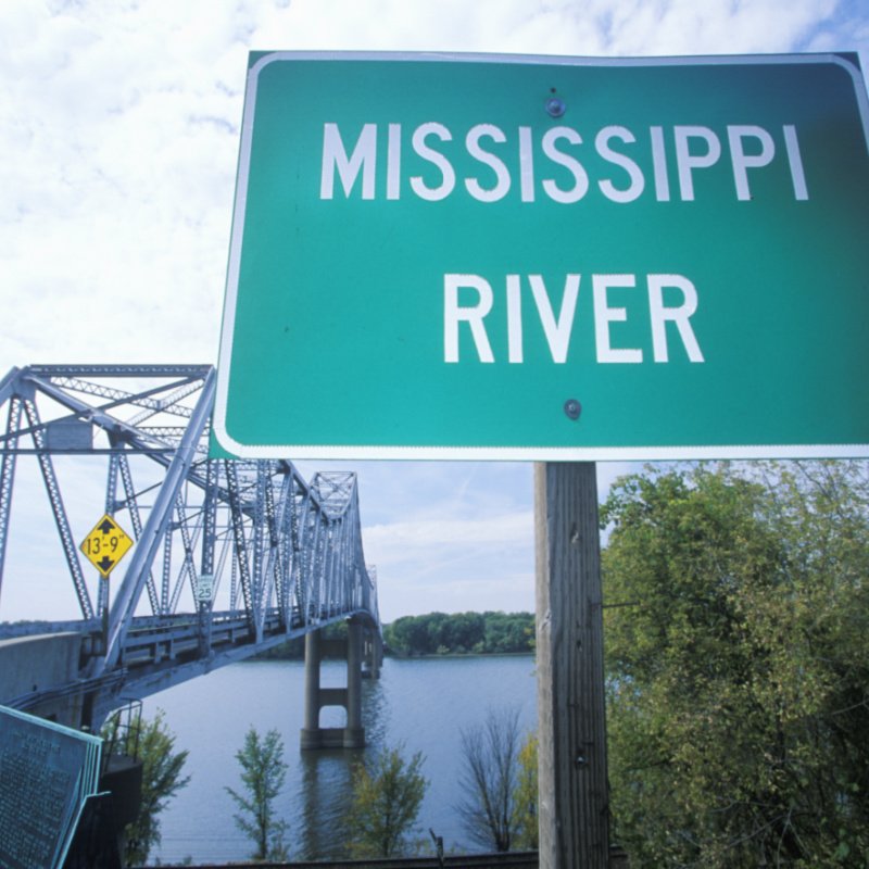 Mississippi River sign in front of a truss bridge