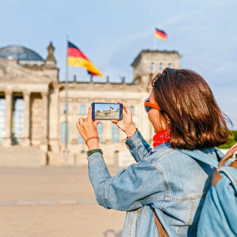 Young Female Tourist Taking A Picture Of The Bundestag In Berlin, Germany