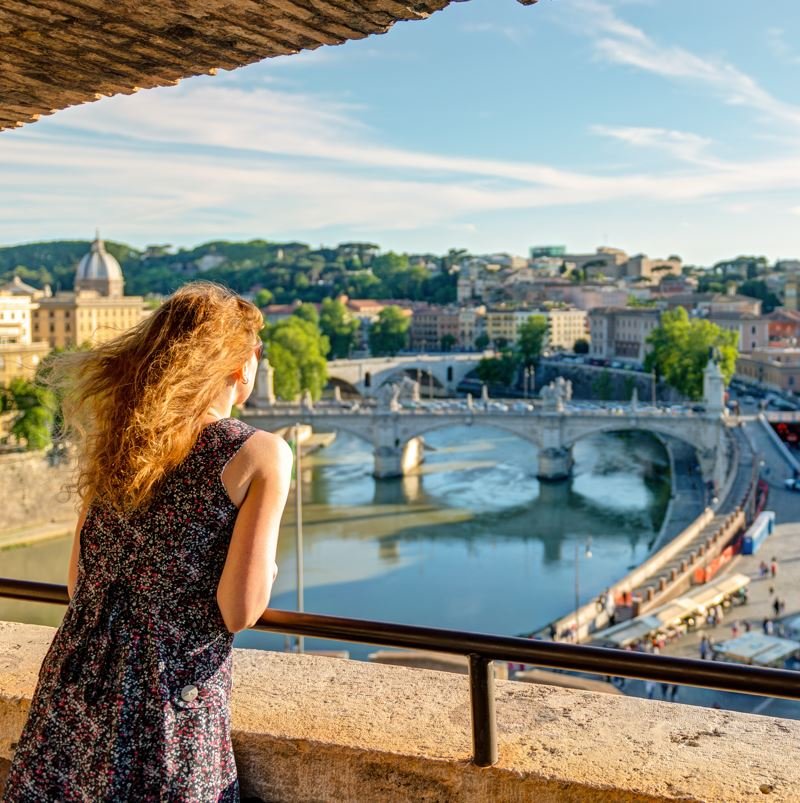 Woman looking out over rome from a bridge