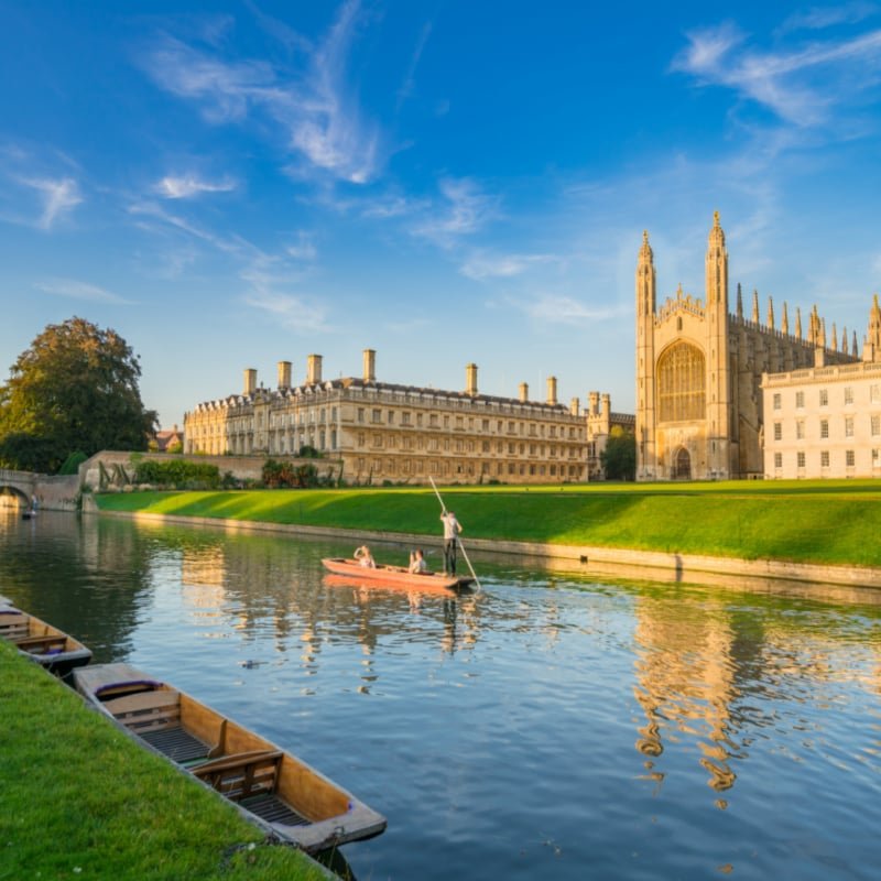 Beautiful view of college in Cambridge with people punting on river cam