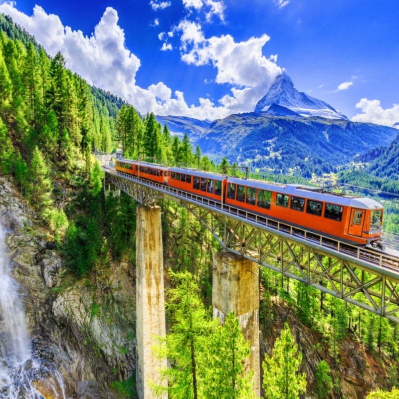 Zermatt, Switzerland. Gornergrat tourist train with waterfall, bridge and Matterhorn. Valais region