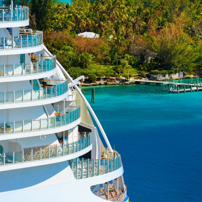 Cruise ship balconies with a tropical shoreline in the background