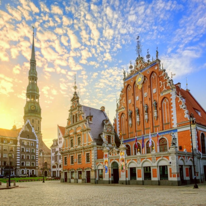 City Hall Square with House of the Blackheads and Saint Peter church in Old Town of Riga on dramatic sunrise, Latvia