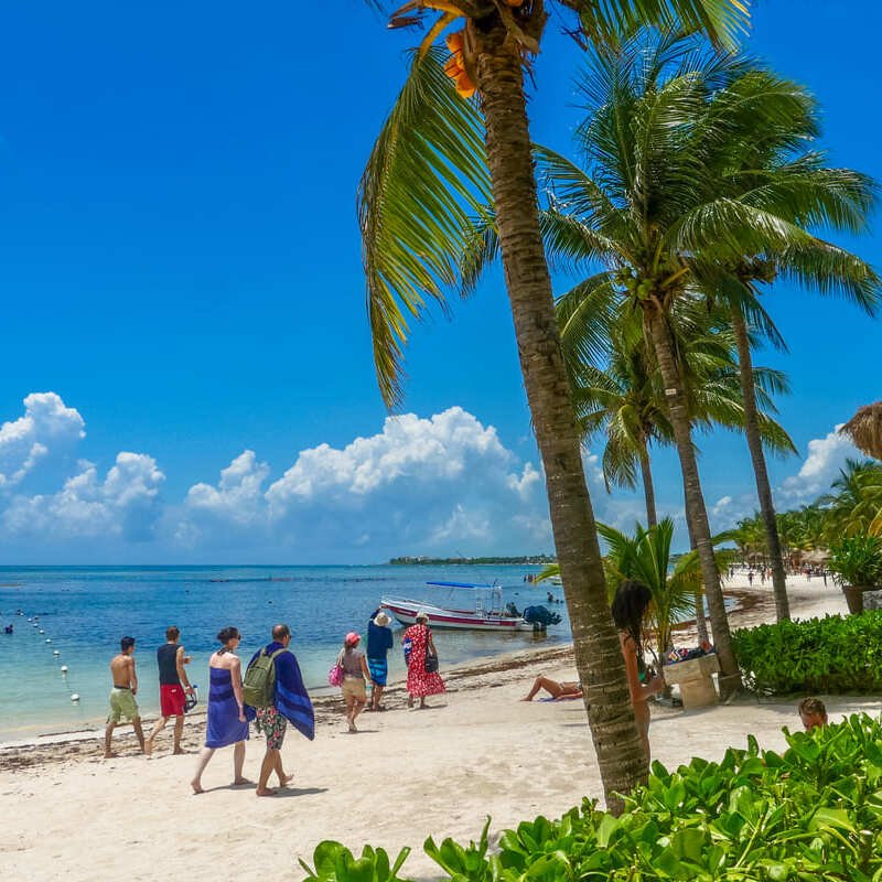 Beachgoers Walking Along A Beach Lined With Palm Trees On The Caribbean Coast Of Mexico, Akumal, Quintana Roo