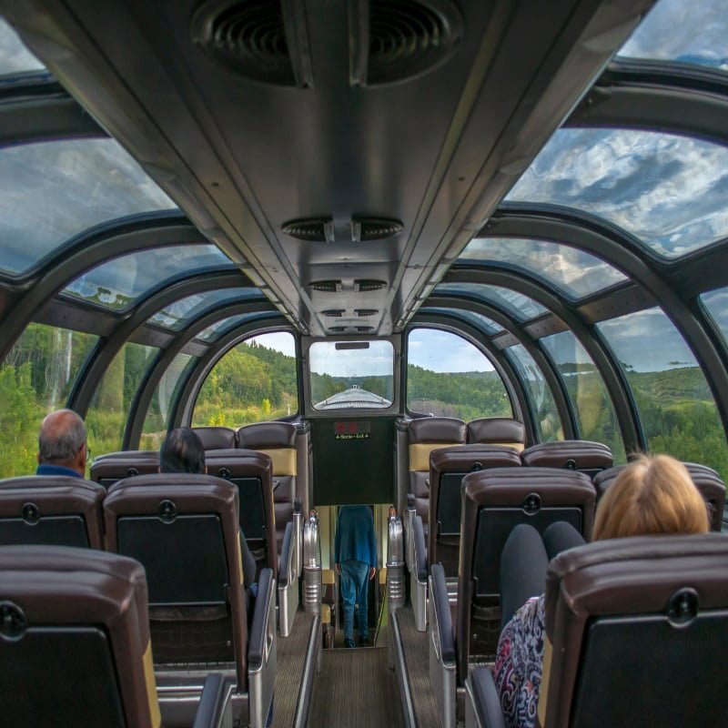 Passenger train observation car offers a wide expanse of glass for scenic viewing.