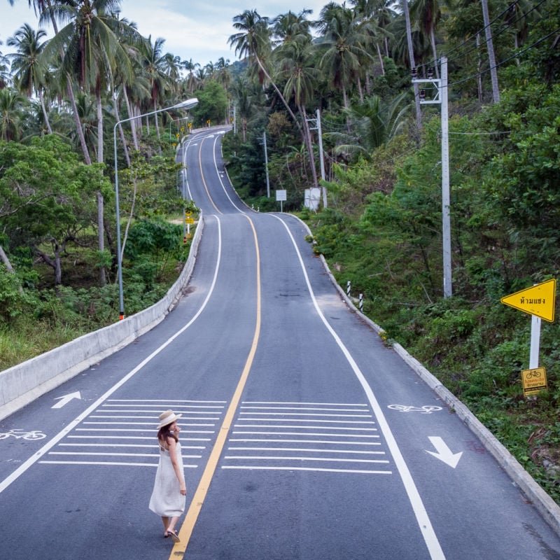 female on empty road in Thailand