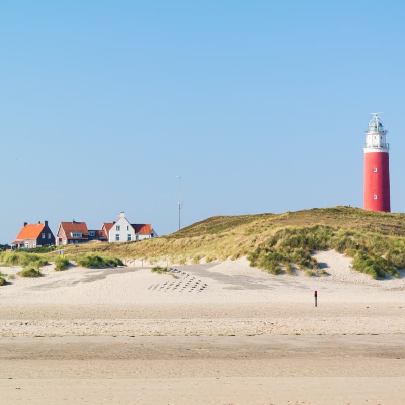 Beach, dunes and lighthouse of De Cocksdorp on West Frisian Waddensea island Texel, Netherlands