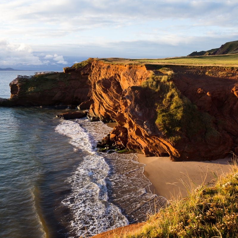 High angle view of red sandstone cliffs and Dunes-du-Sud beach seen during a sunny fall sunrise, Havre-aux-Maisons, Magdalen Islands, Quebec, Canada