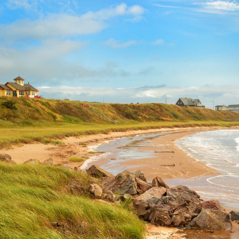 Beautiful yellow house by the sea. Rugged cost line of Havre Aubert in magdalen island in Quebec, Canada