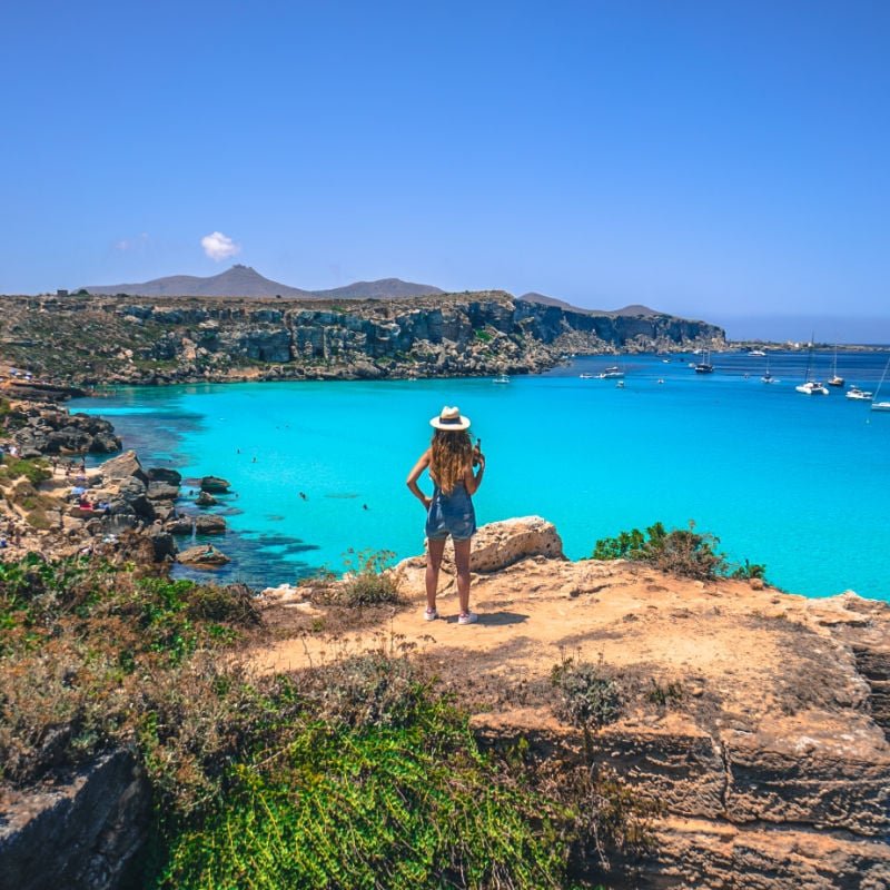 Girl in Cala rossa Bay. Beach in Favignana Island