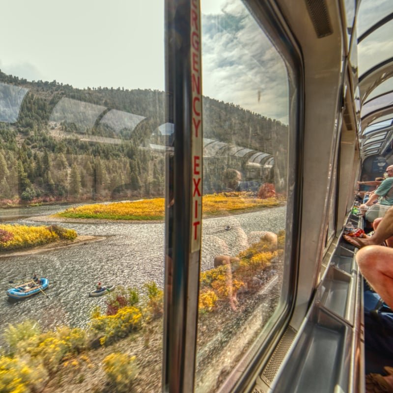 people riding a train in the fall