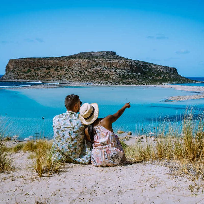 Young Couple Admiring The View In A Greek Island, Greece, Mediterranean Sea