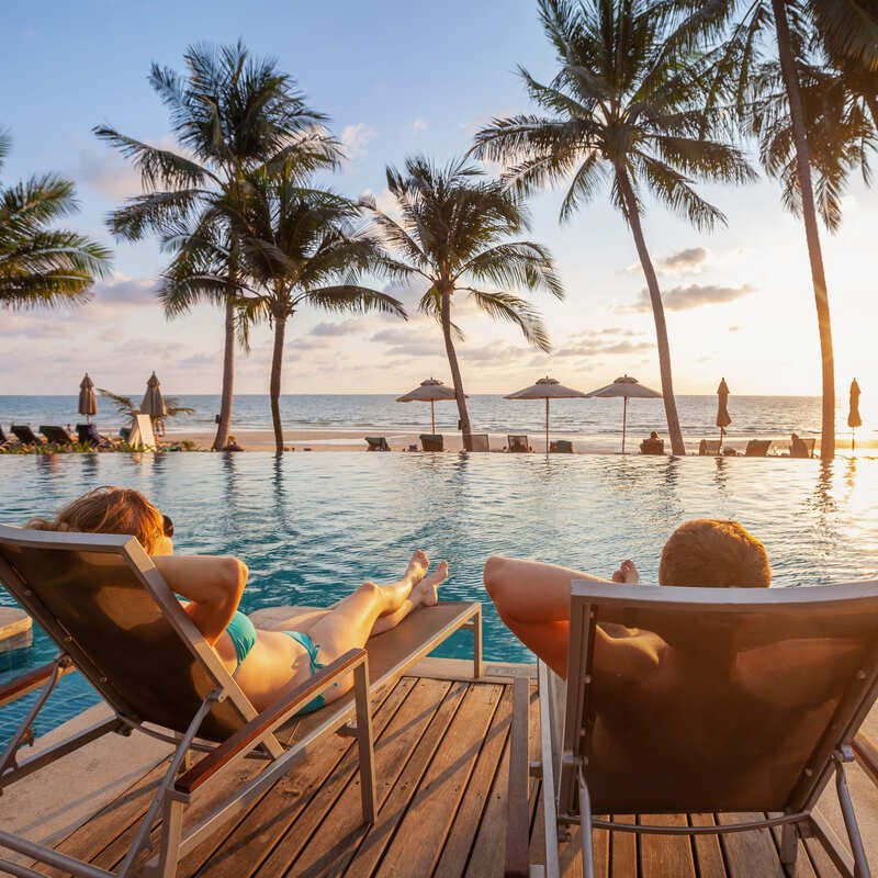 Couple Relaxing By The Poolside In A Los Cabos Resort, Los Cabos, Mexico