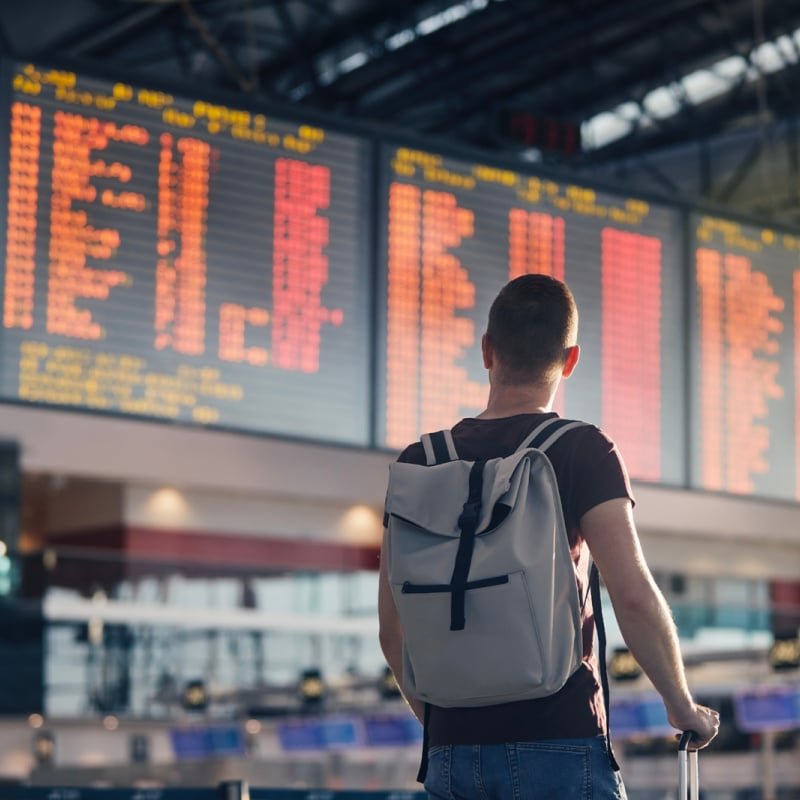 traveler at airport flight board