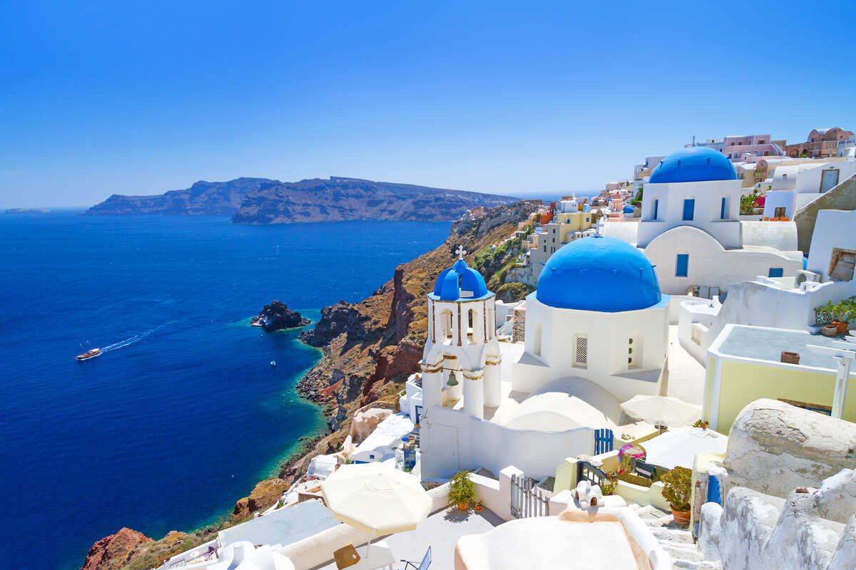 Panoramic View Of Whitewashed Village Of Oia, In The Island Of Santorini, Greece, South Eastern Europe